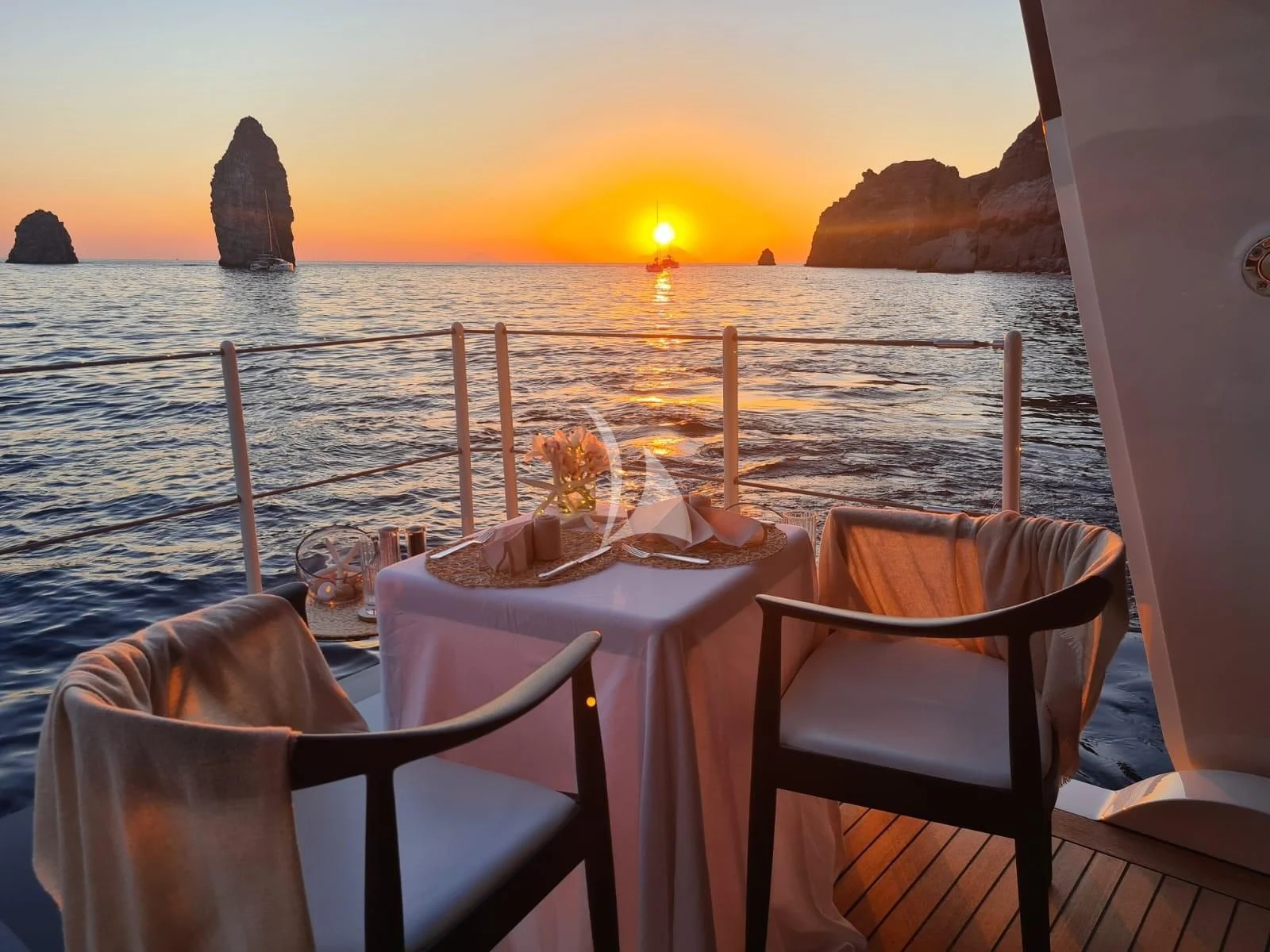 a table set for dinner on a boat at sunset aboard KAMALAYA Yacht for Sale