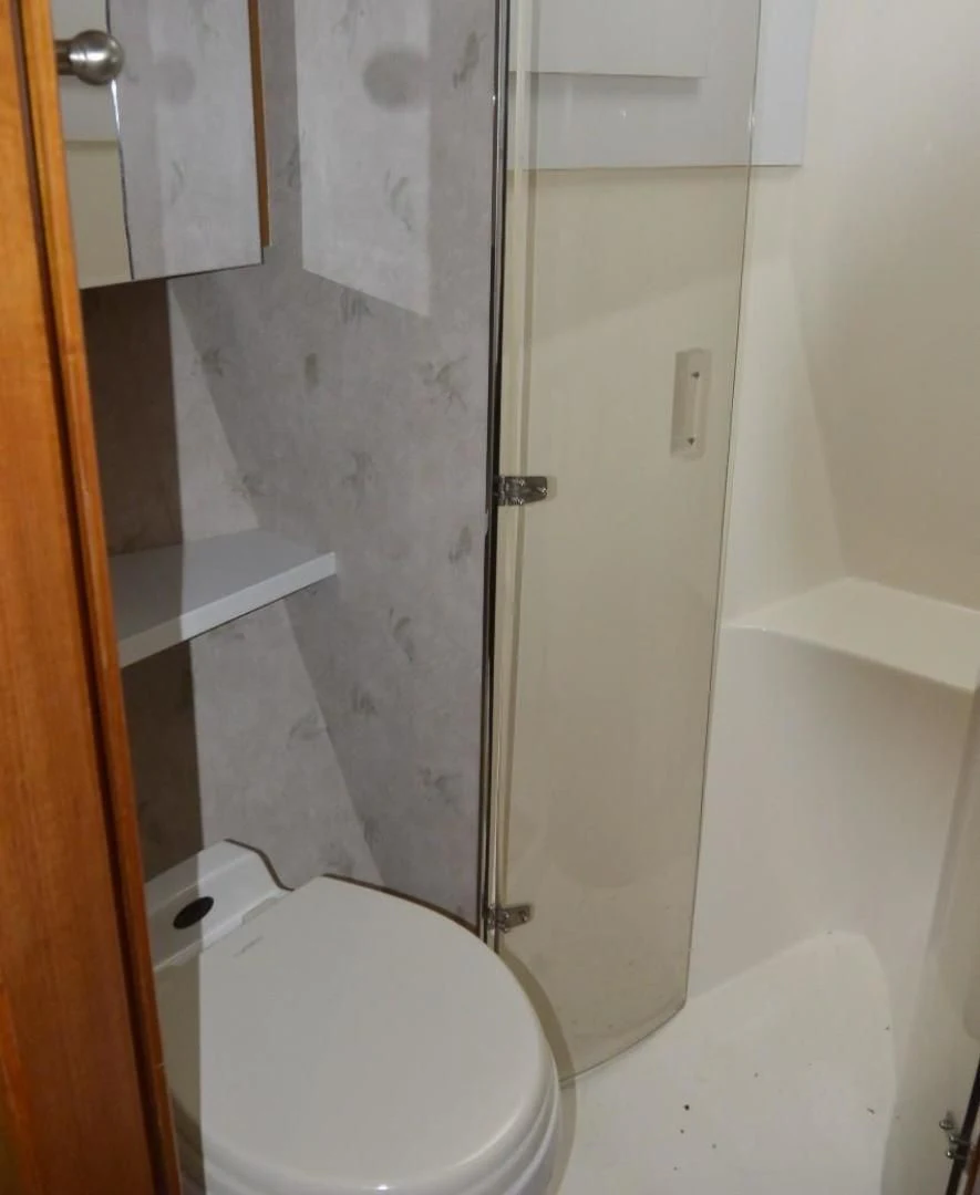 a bathroom with a toilet and a shower aboard DOG HOUSE Yacht for Sale