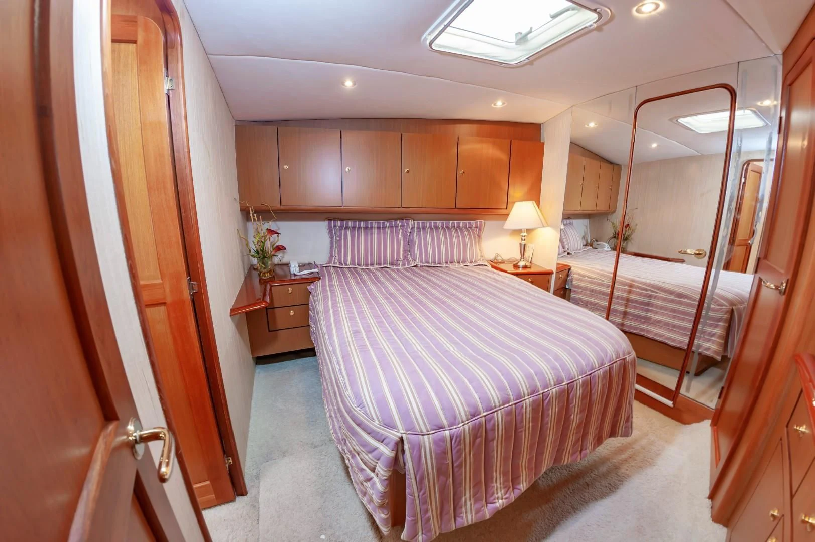 a bedroom with a bed and a mirror aboard DOG HOUSE Yacht for Sale