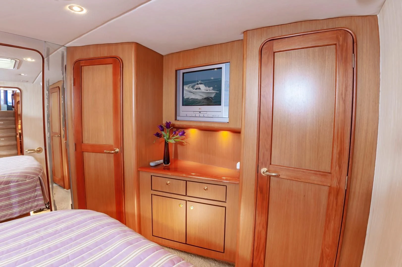 a bedroom with a bed and a wood cabinet aboard DOG HOUSE Yacht for Sale