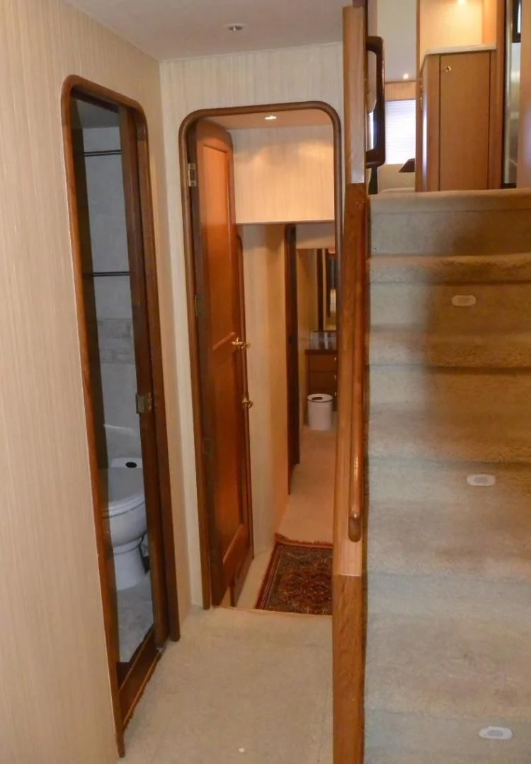 a bathroom with a toilet and a wood door aboard DOG HOUSE Yacht for Sale