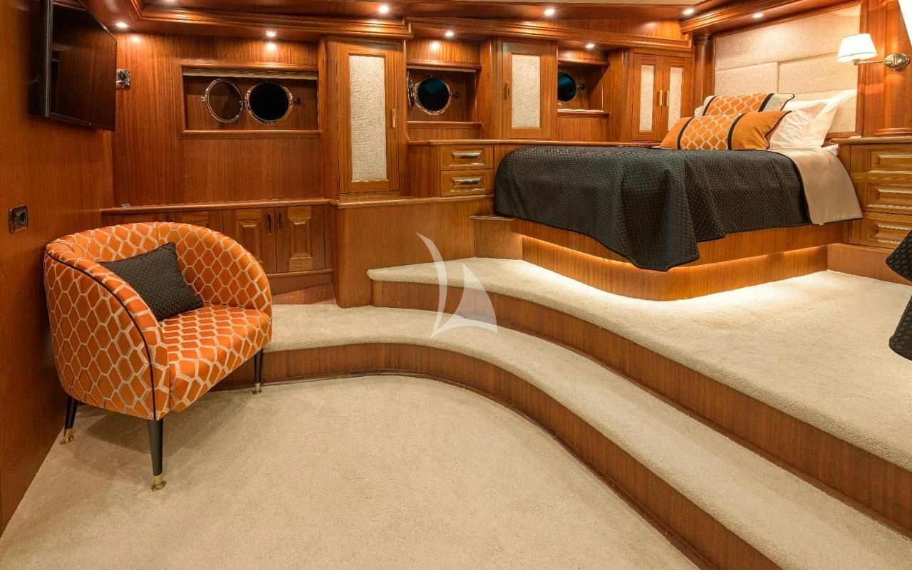 a bed and chair in a room aboard KAPTAN KADIR Yacht for Sale