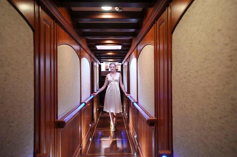 a person in a white dress walking down a flight of stairs aboard KAPTAN KADIR Yacht for Sale