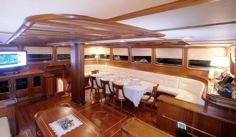 a room with a table and chairs aboard KAPTAN KADIR Yacht for Sale