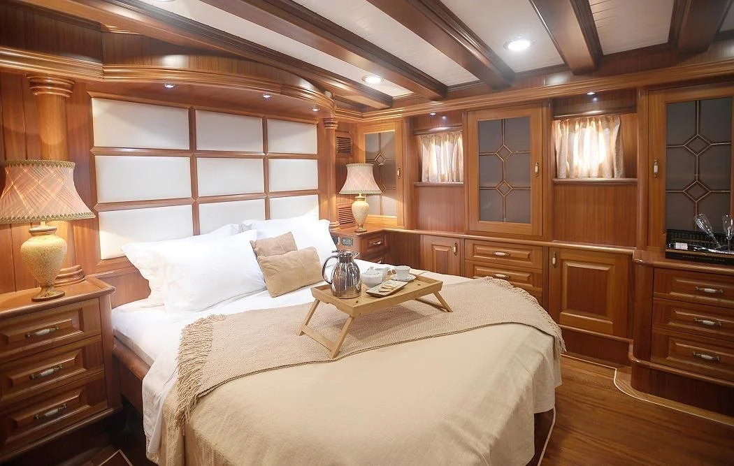 a bedroom with a bed and a desk aboard KAPTAN KADIR Yacht for Sale
