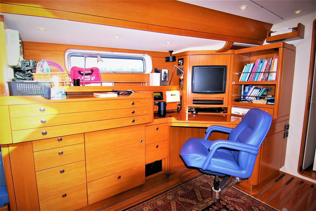 a room with a tv and bookshelf aboard LEONORE Yacht for Sale