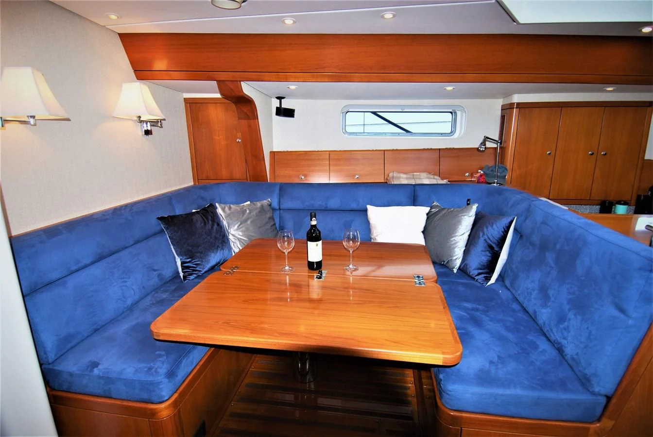 a wine bottle and glass on a table in a room aboard LEONORE Yacht for Sale