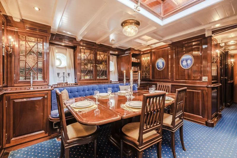 a large dining room with wood walls aboard DORIANA Yacht for Sale