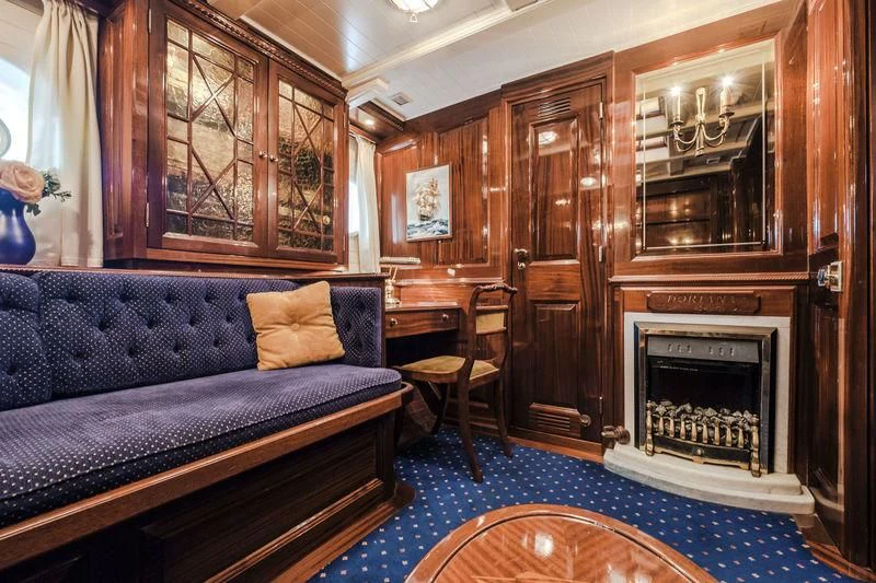 a living room with a blue couch aboard DORIANA Yacht for Sale