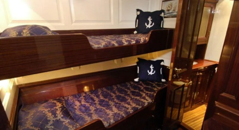 a bed with a blue pillow aboard DORIANA Yacht for Sale