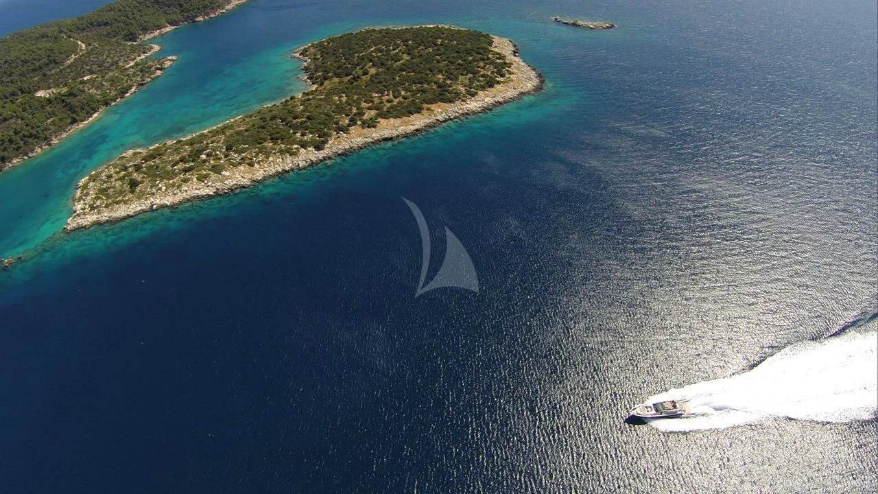 a beach with a cliff and a body of water aboard SOLARIS Yacht for Sale