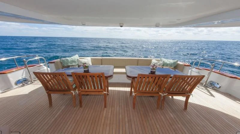a deck with tables and chairs on it aboard ANNDRIANNA Yacht for Sale