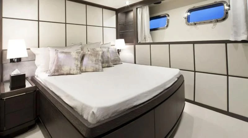 a bed with a white sheet and pillows aboard MUSE Yacht for Sale