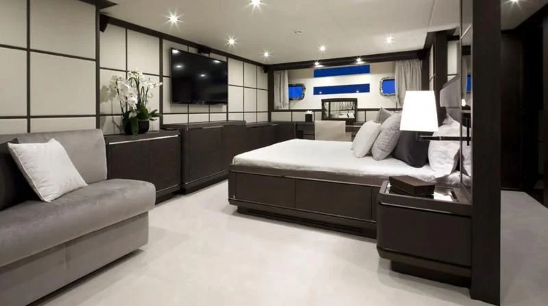 a large bedroom with a bed and a couch aboard MUSE Yacht for Sale
