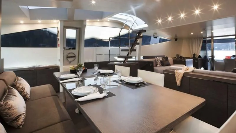 a living room with a large table aboard MUSE Yacht for Sale