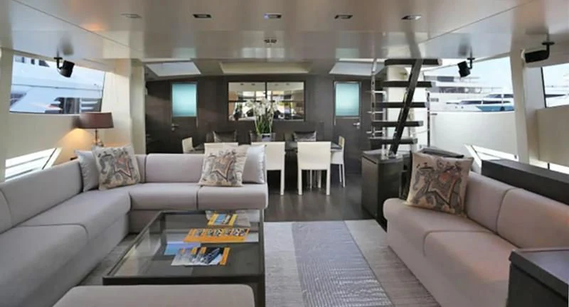 a living room with a large sofa and a coffee table aboard MUSE Yacht for Sale