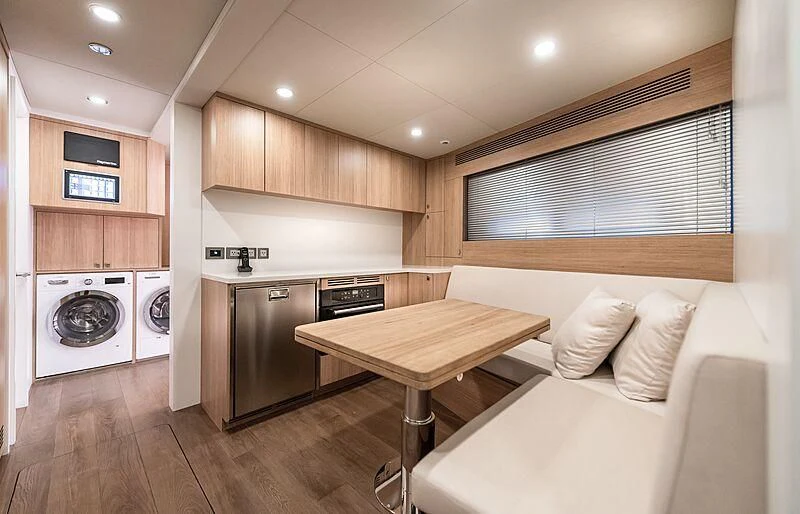 a kitchen with a table and a couch aboard MASHA Yacht for Sale