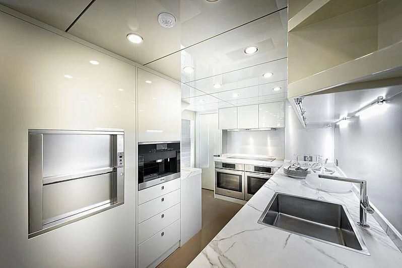 a kitchen with white cabinets aboard MASHA Yacht for Sale