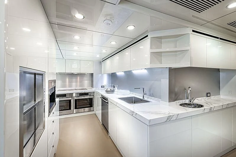 a kitchen with white cabinets aboard MASHA Yacht for Sale