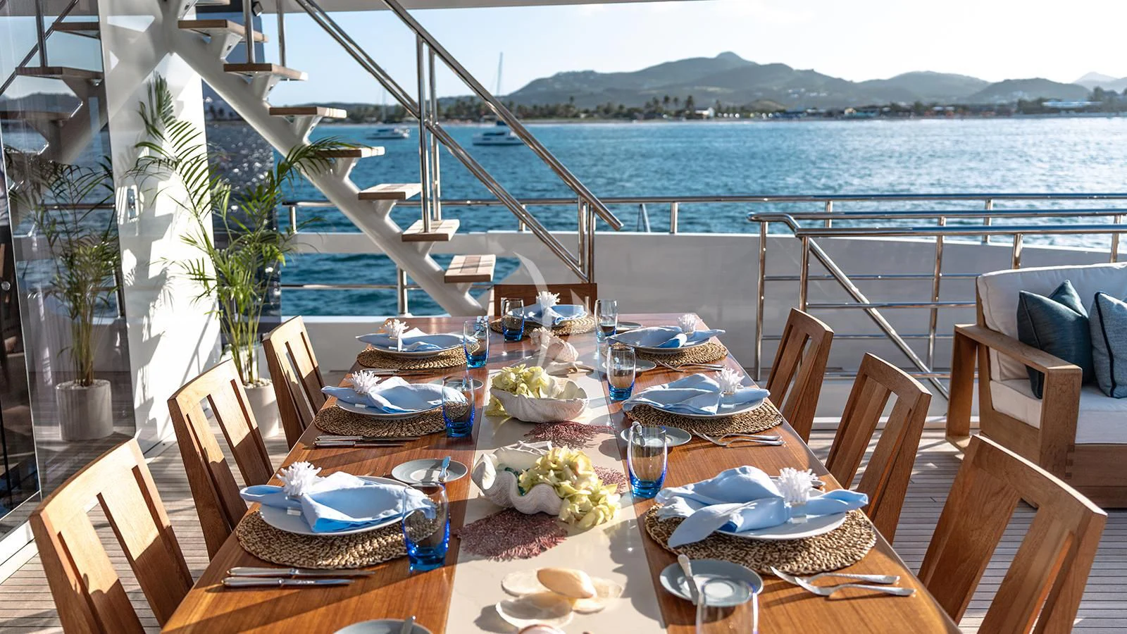a table set for a meal on a balcony overlooking the ocean aboard MOSKITO Yacht for Sale