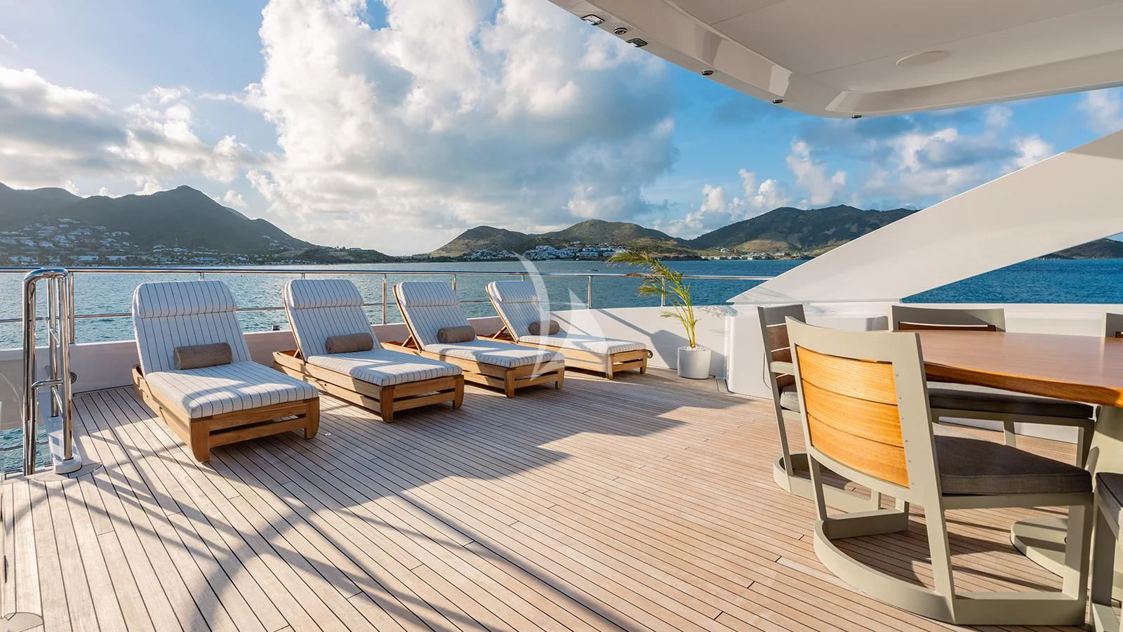 a deck with chairs and a body of water in the background aboard MOSKITO Yacht for Sale
