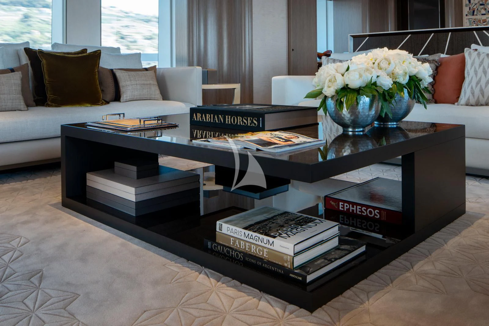 a coffee table with books on it aboard MOSKITO Yacht for Sale