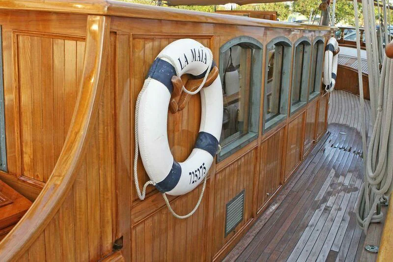 a white and blue baseball glove on a wooden deck aboard LA MAIA Yacht for Sale