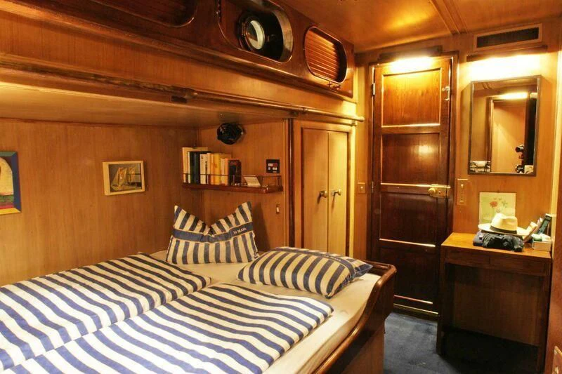 a bedroom with a bed and a desk aboard LA MAIA Yacht for Sale