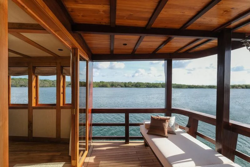 a wood deck with a view of a lake and trees aboard CELESTIA Yacht for Sale