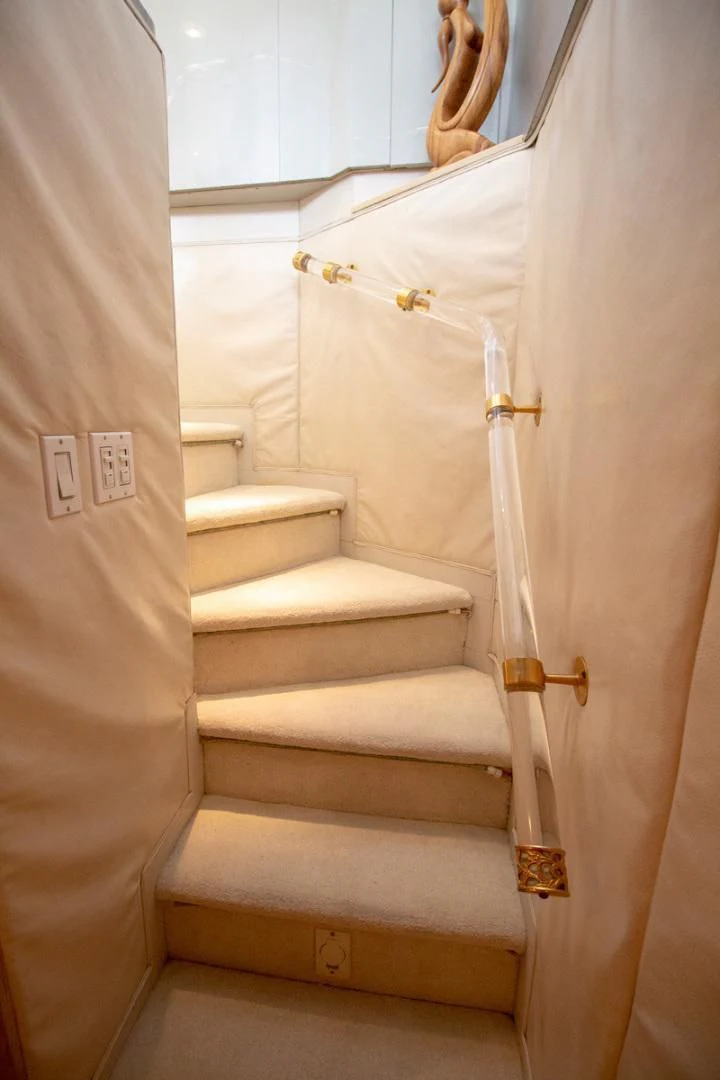 a white staircase with a gold door aboard LIQUIDITY Yacht for Sale