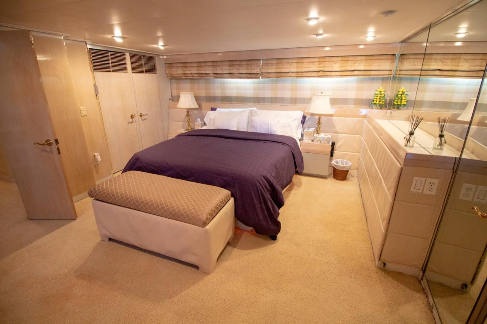a large bedroom with a large purple bed aboard LIQUIDITY Yacht for Sale