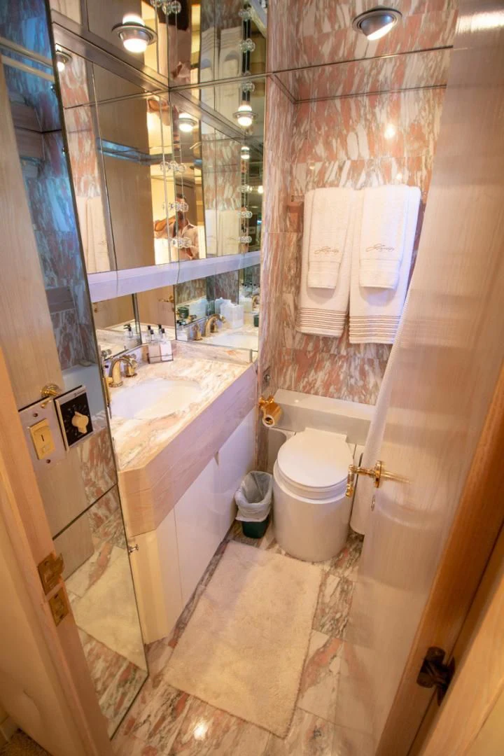 a bathroom with a toilet and tub aboard LIQUIDITY Yacht for Sale