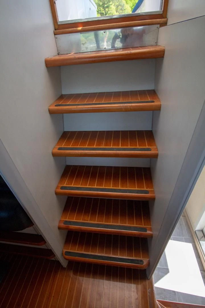 a wooden staircase with a window aboard LIQUIDITY Yacht for Sale