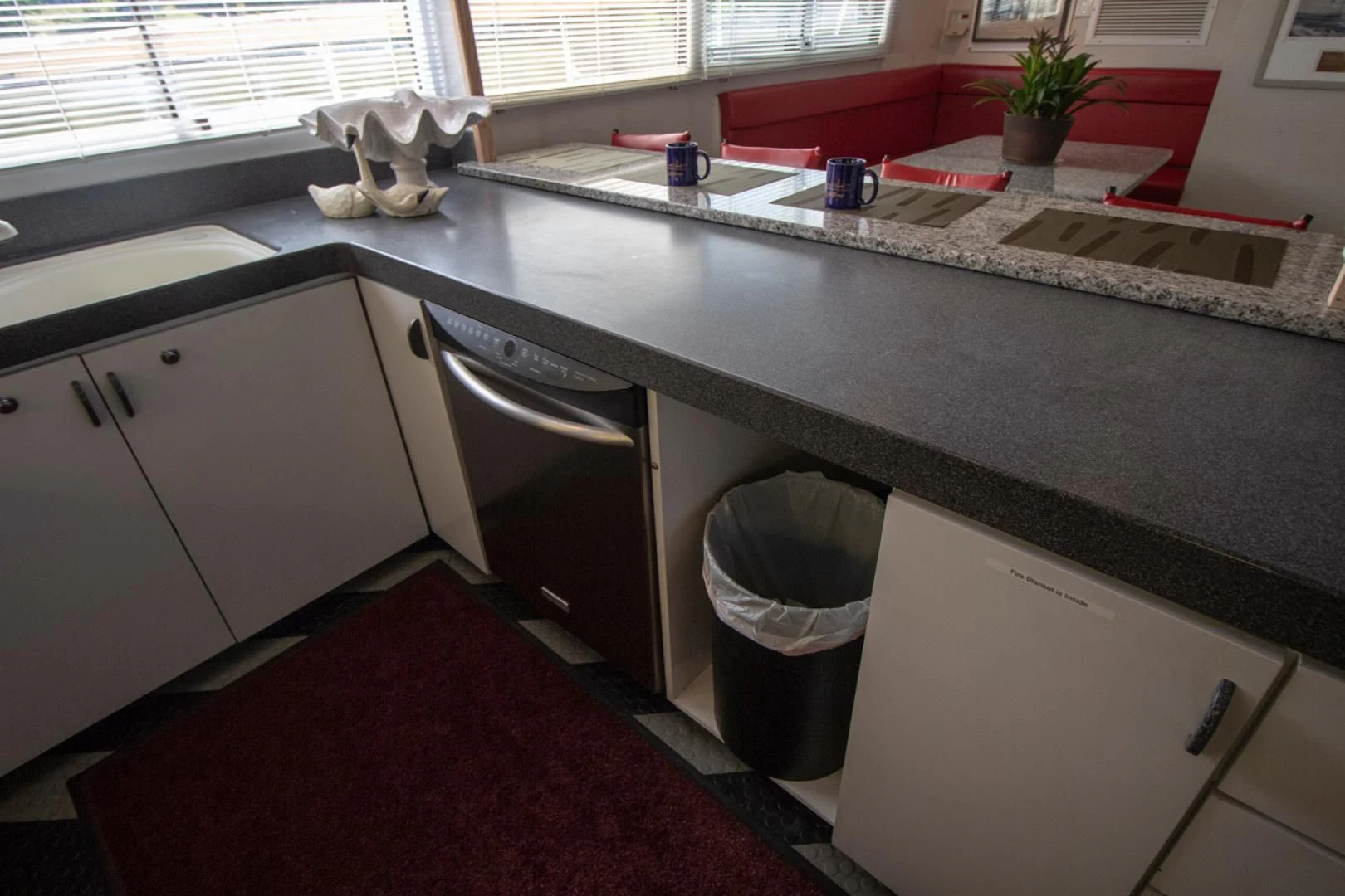 a kitchen with a sink and a trash can aboard LIQUIDITY Yacht for Sale