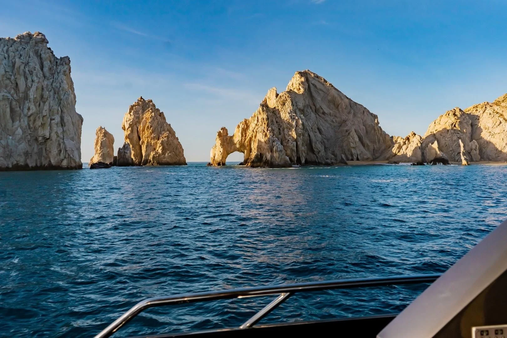 a boat on the water with Arch of Cabo San Lucas in the background aboard SAVI II Yacht for Sale