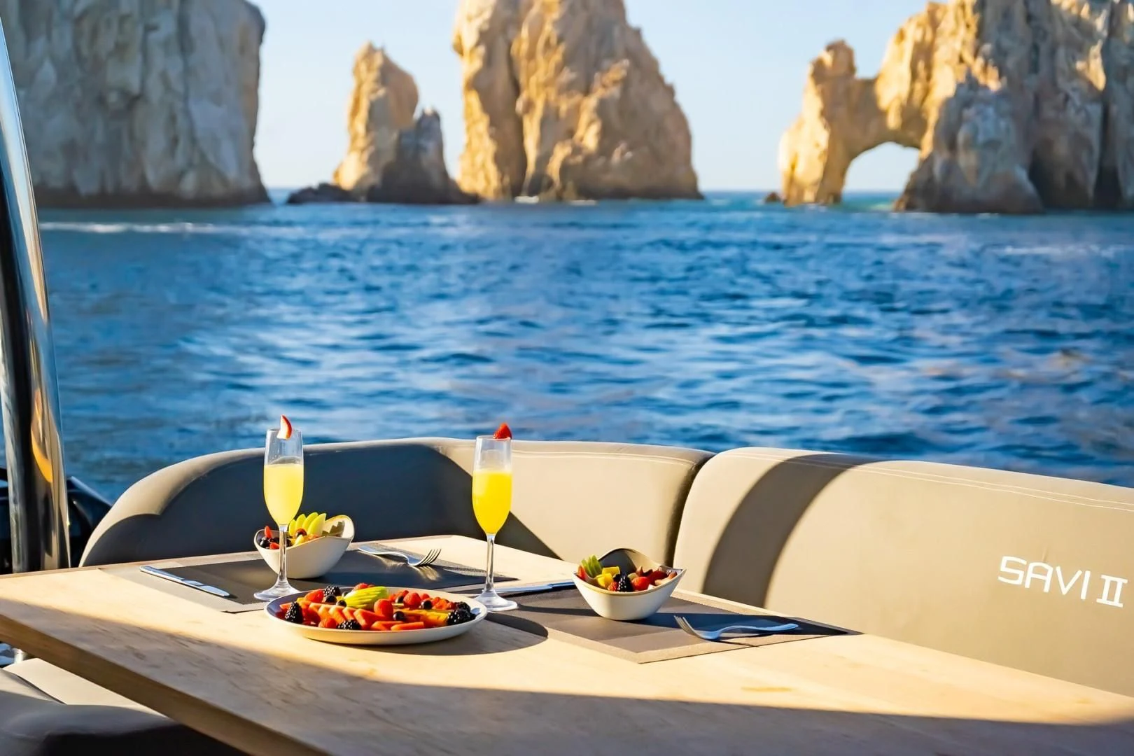 a table with food and drinks on it by the water aboard SAVI II Yacht for Sale