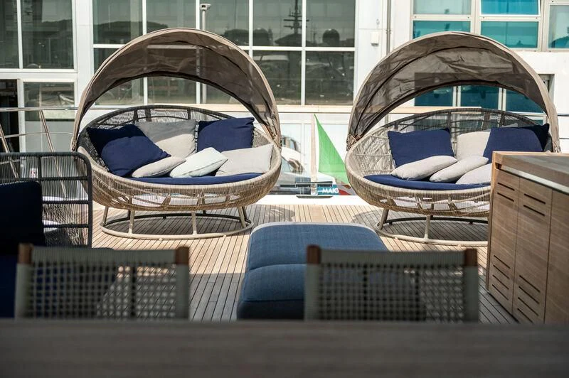 a wicker chair with a blue blanket on it aboard VISSOTTA Yacht for Sale