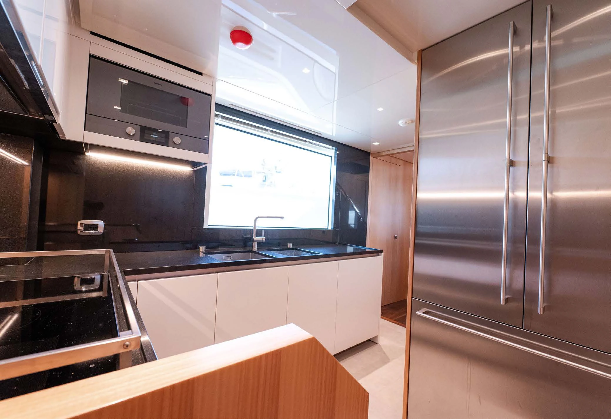 a kitchen with a stainless steel refrigerator aboard VISSOTTA Yacht for Sale