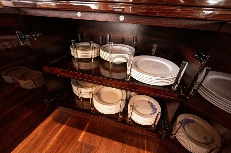a wooden shelf with plates and bowls aboard VISSOTTA Yacht for Sale