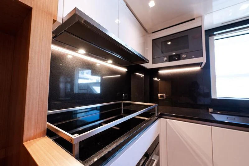 a kitchen with a stove and microwave aboard VISSOTTA Yacht for Sale