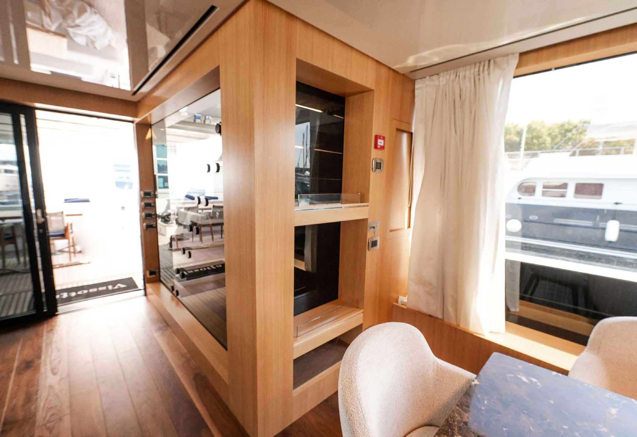 a room with a wood floor and a window with a view of the outside aboard VISSOTTA Yacht for Sale
