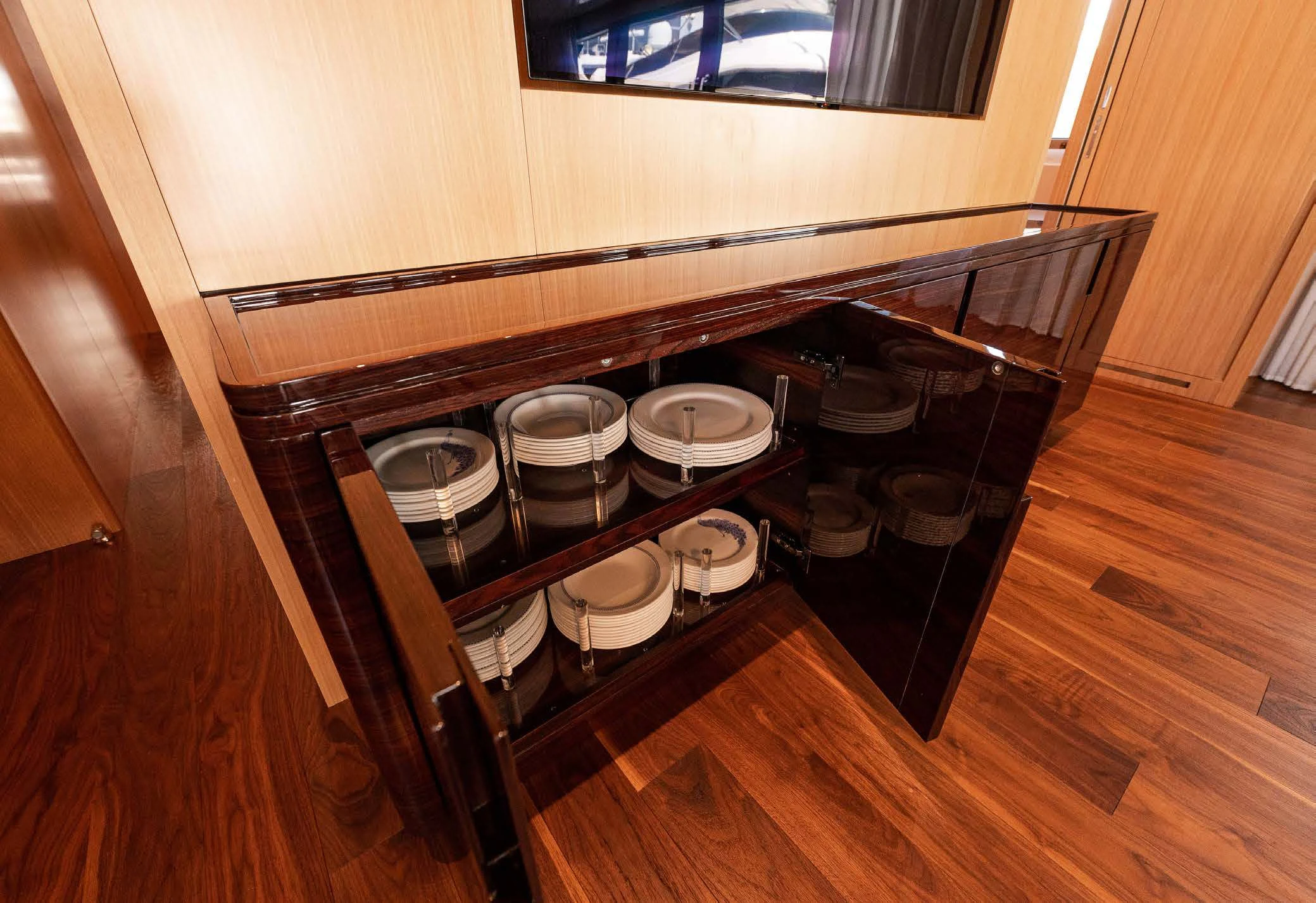 a wooden cabinet with a shelf of plates and cups on it aboard VISSOTTA Yacht for Sale