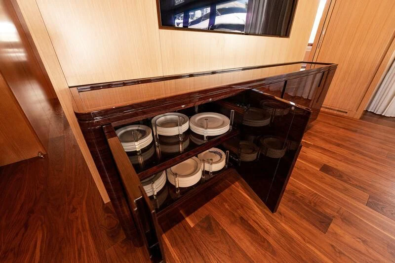 a wooden table with plates and cups aboard VISSOTTA Yacht for Sale