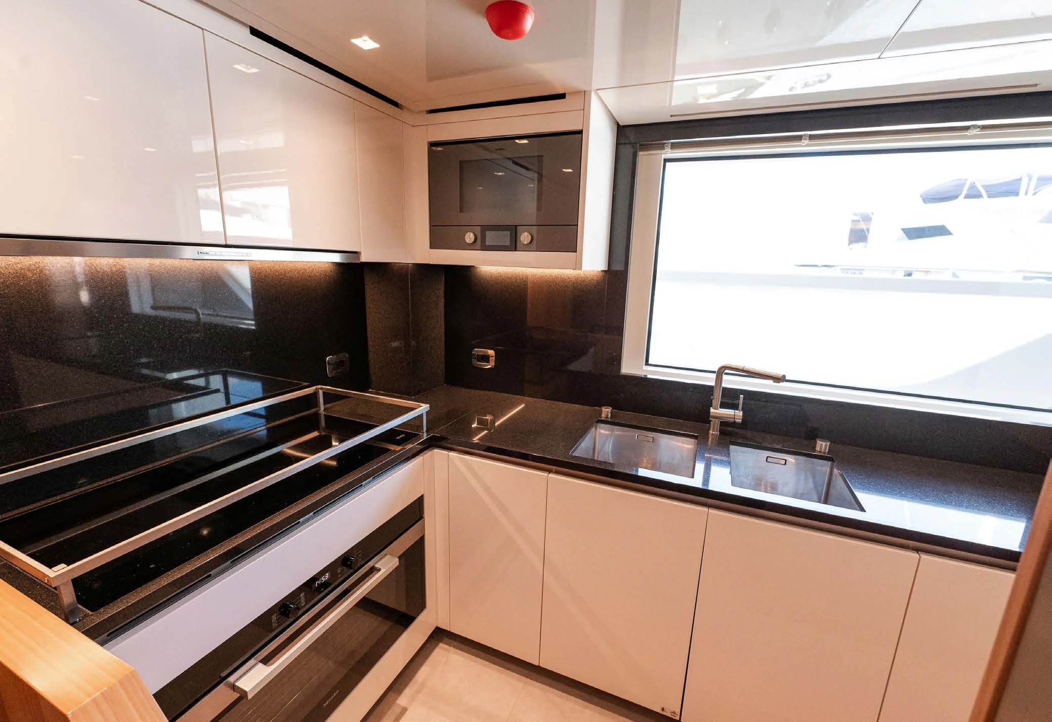 a kitchen with a stove and a window aboard VISSOTTA Yacht for Sale