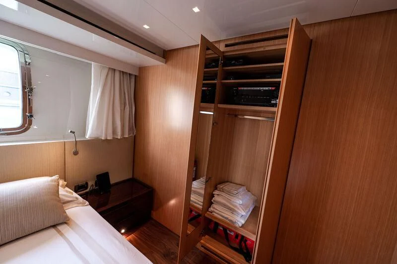 a room with a bed and a shelf with books on it aboard VISSOTTA Yacht for Sale