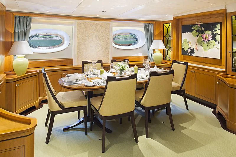 a dining table with chairs and a large mirror aboard WISP Yacht for Sale