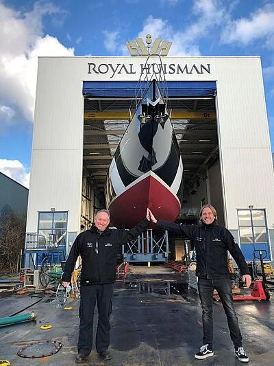 a couple of men posing in front of a large satellite dish aboard WISP Yacht for Sale