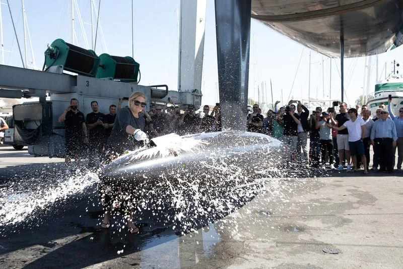 a group of people standing in water next to a large boat aboard BULLITT Yacht for Sale
