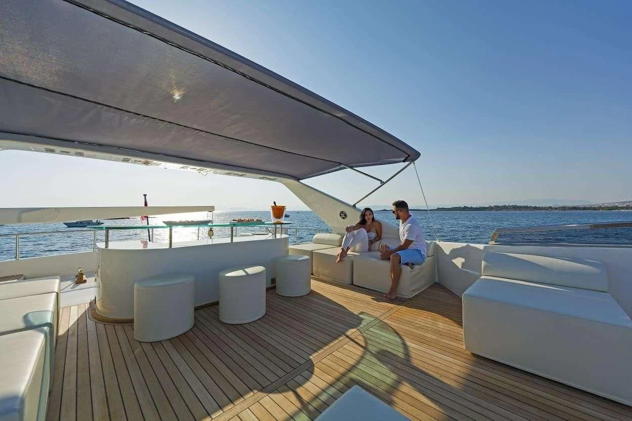 a couple sitting on a deck of a boat on the water aboard ILLYA F Yacht for Charter