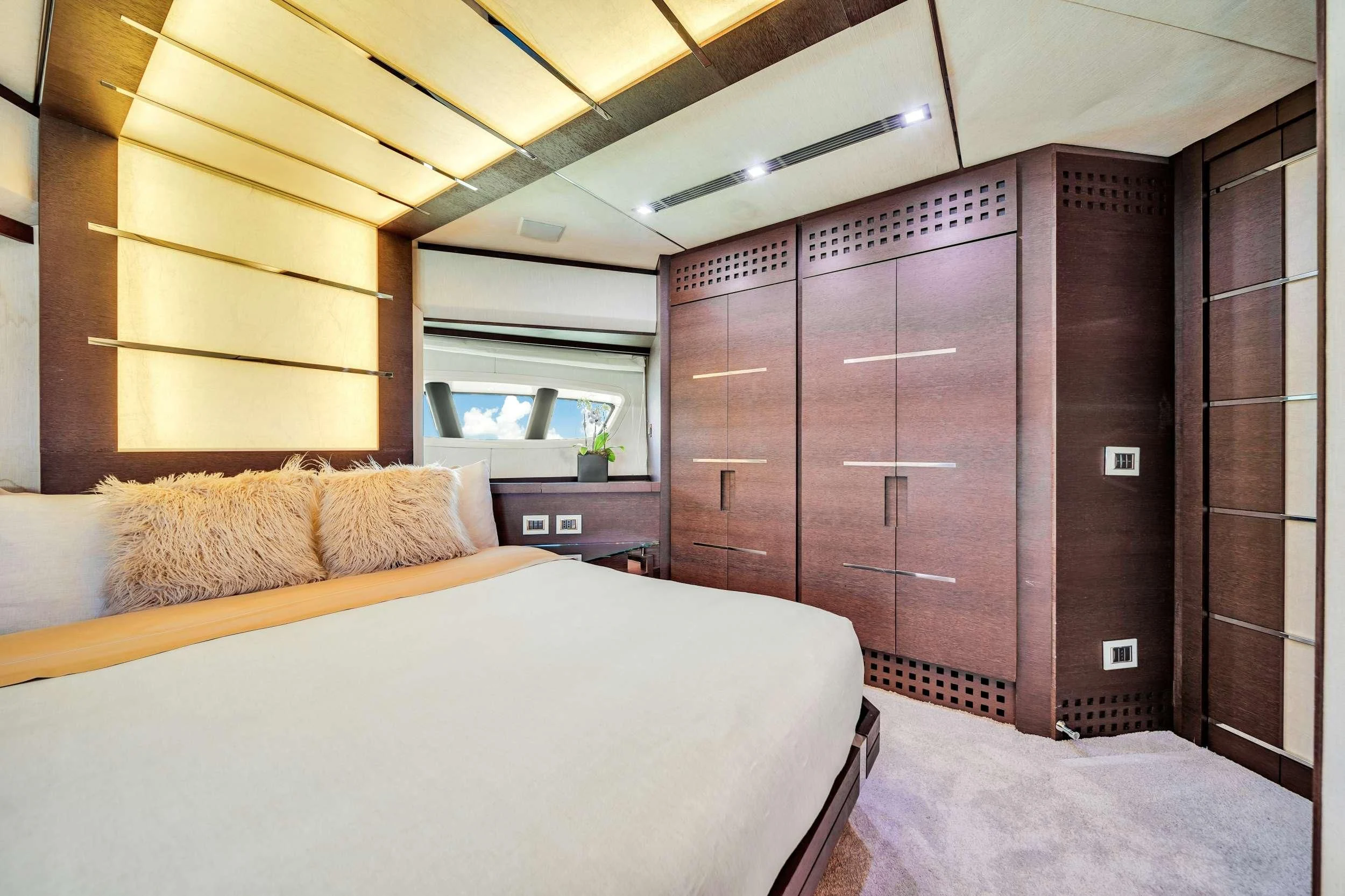 a room with a bed and a wood cabinet aboard SETTE Yacht for Sale